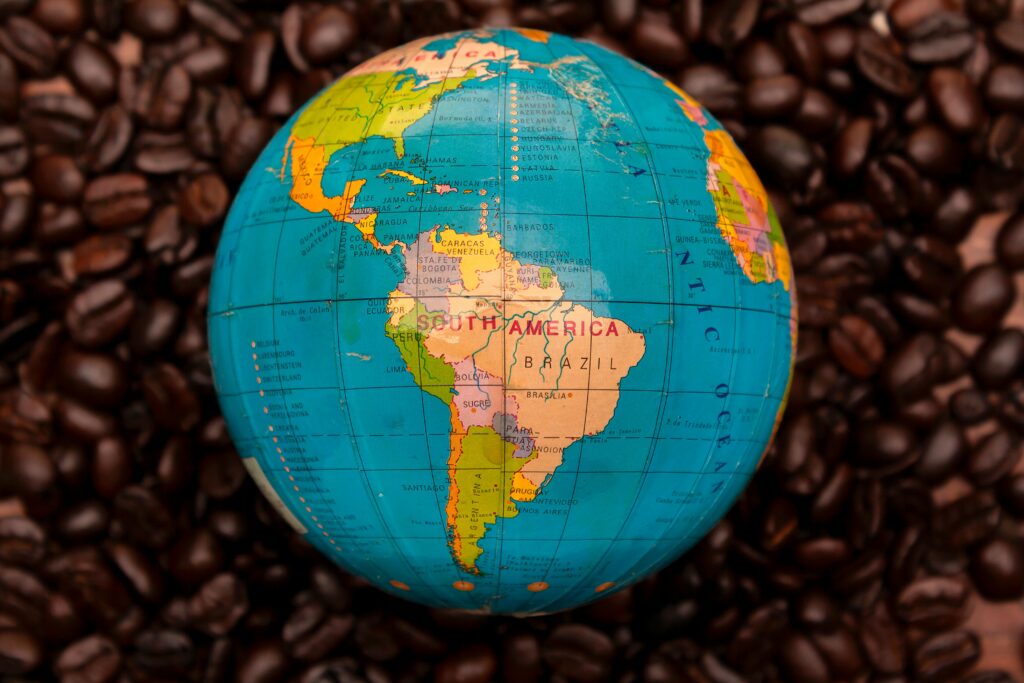 Close-up of South American globe encircled by rich coffee beans, emphasizing geography and culture.